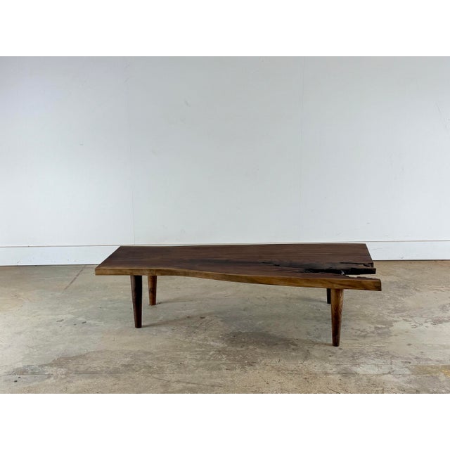 This one-of-a-kind handcrafted walnut coffee table celebrates the beauty of imperfection and natural process. The solid...