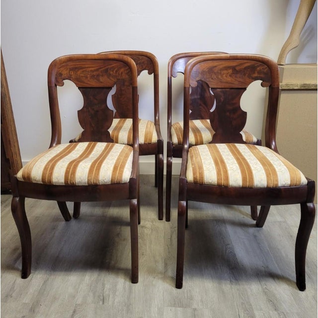 A refined set of four Biedermeier-style dining chairs dating to the late 19th or early 20th century, crafted in warm...