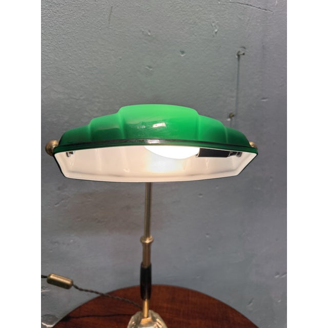 Refined Churchill table lamp from the early 1900s, made of brass with a green opaline glass shade (white inside). An...