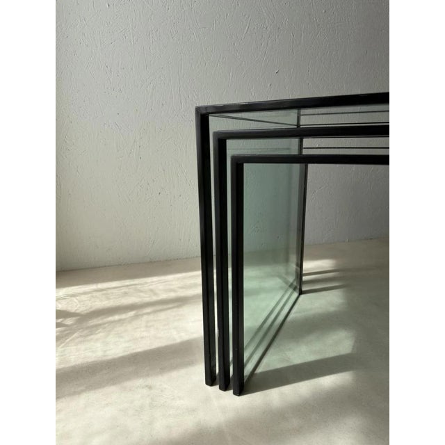 Set of three postmodernist nesting tables, glass and black metal, 1980s. Some designs are built on form, others on...