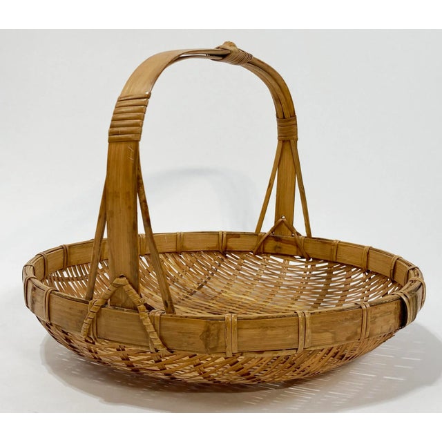 Large vintage round burnt tortoise shell rattan wicker basket tray. Features loose weave and thick rim with sturdy...