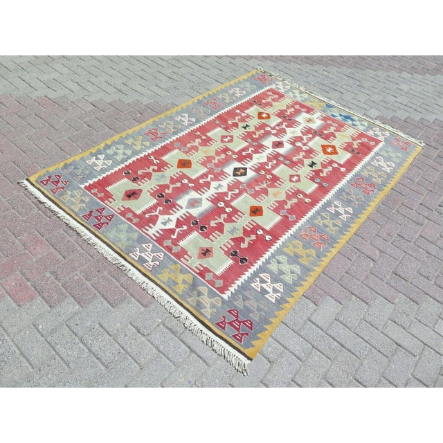 This beautiful, traditional vintage, flatweaved Turkish kilim rug is approximately 60 years old. It is handmade of very...