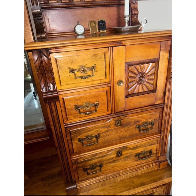 Beautiful Victorian Revival gentleman’s dresser featuring a dramatic cheval mirror, richly carved detailing, paneled...