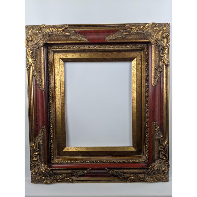 This is a substantial, highly decorative frame with a rich red finish accented by antique gold gilt tones. The wide...