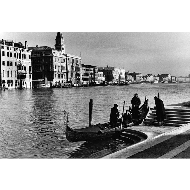 This timeless black-and-white photograph captures a tranquil moment along the Grand Canal in Venice, showcasing the iconic...