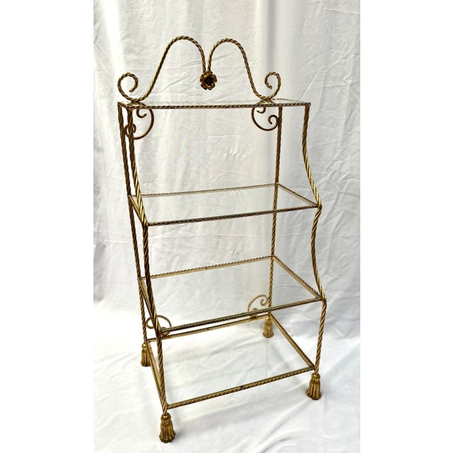Twisted cable gold gilt etagere with four graduated shelves. The crown is arched with a rosette center. The four glass...