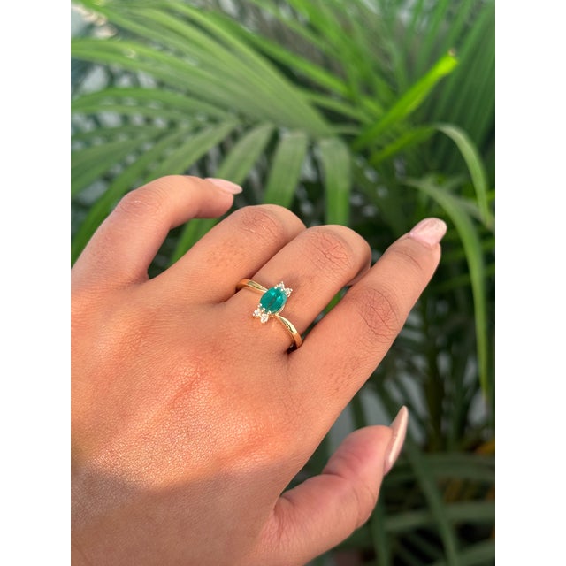 This cluster ring is featuring a 0.84 carats oval cut emerald set in 14K yellow gold. The emerald measuring approximately...