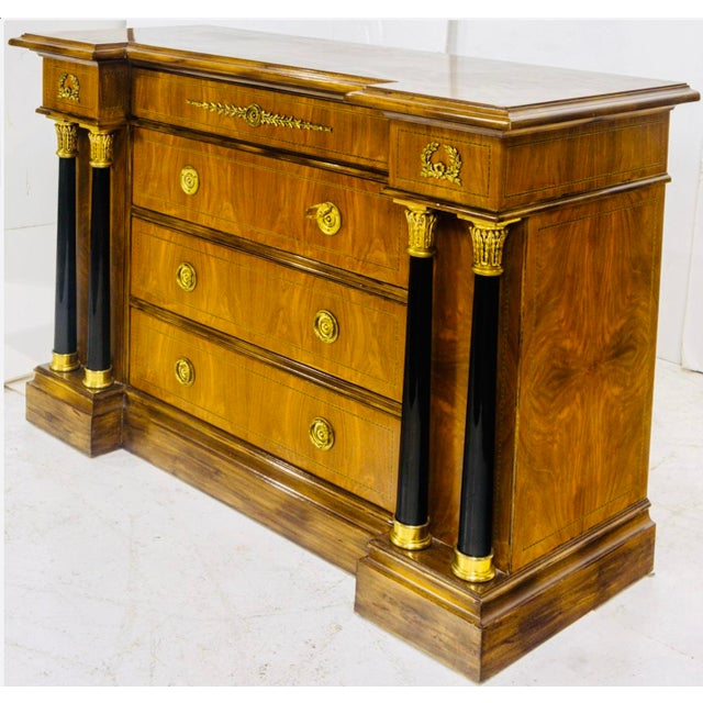 A bold and highly architectural French Empire Revival chest of drawers, dating to circa 1890–1910, and likely produced in...