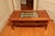 I purchased this wood (I believe oak but not sure what species) coffee table for my arts and crafts-styled living room...