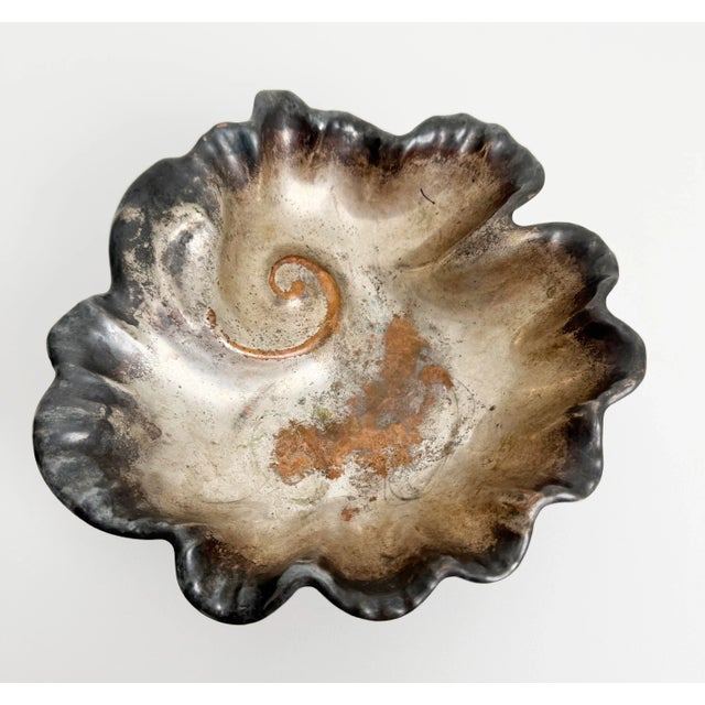 Rustic vintage silver-plated bowl with a nautilus shell design. The bowl has a ruffled edge and a spiral pattern in the...
