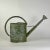 This large vintage European metal watering can is beautiful in form to begin with, and the remnant avocado green paint...