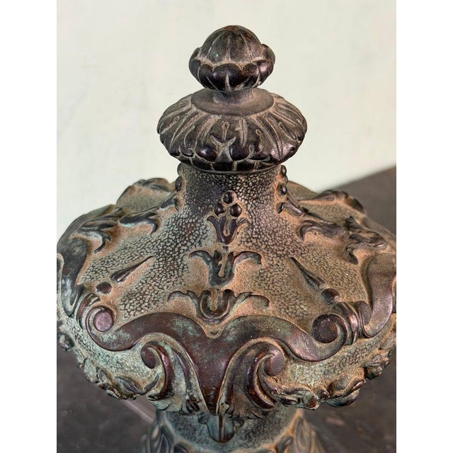 A richly detailed 19th-century cast iron finial, showcasing elaborate Baroque Revival ornamentation with scrolling...