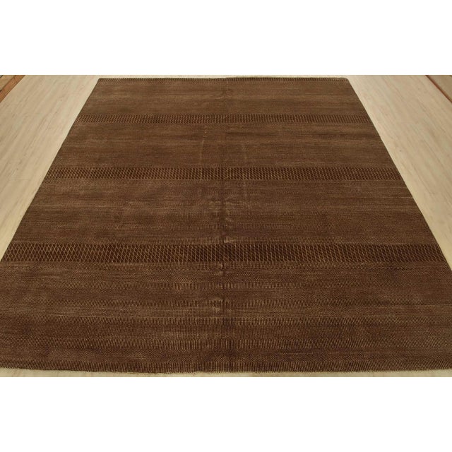 A contemporary rug hand-knotted with an all-wool pile on a cotton foundation. This finely woven area rug features small-...