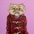 The artwork features a whimsical portrayal of a cat with an exaggerated, expressive face, dressed in a cozy, plaid jacket...