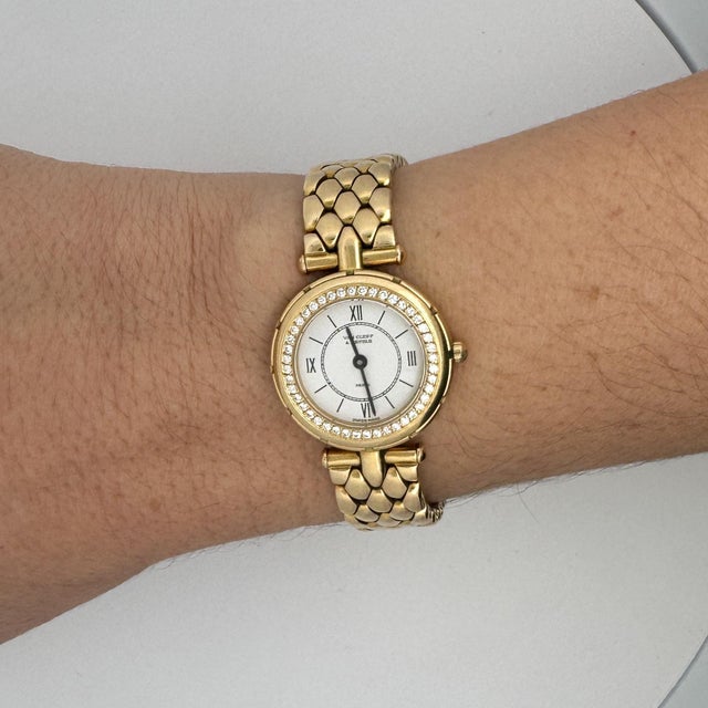 Experience the Van Cleef & Arpels La Collection watch, crafted in 18K yellow gold. Its classic white dial features Roman...