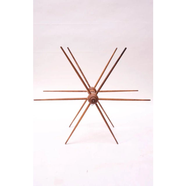 Circa 1940s silk winder from a textile mill with twelve spokes and a small strip of leather around the center shaft....