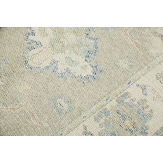 This modern Turkish Oushak rug is a stunning piece of art that has been handwoven using traditional techniques by skilled...
