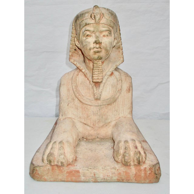 Large red brick cast sphinx with a surface washed in a concrete skin and filled on the interior with a full concrete core....