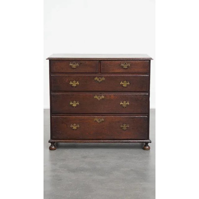 Offered this beautiful antique oak English chest of drawers / dresser from the 18th century with original ball feet and 5...