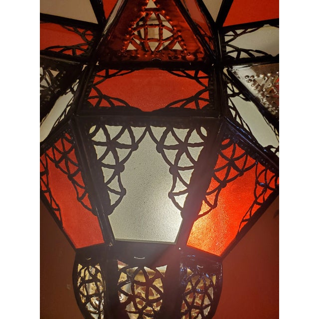 Handmade Moroccan glass lantern with frosty red and white stain glass and metal rustic frame, measuring around 12" in...