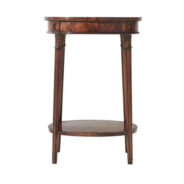 A Regency style flame veneered and mahogany lamp table, the oval top on gently splayed acanthus capital and reeded...