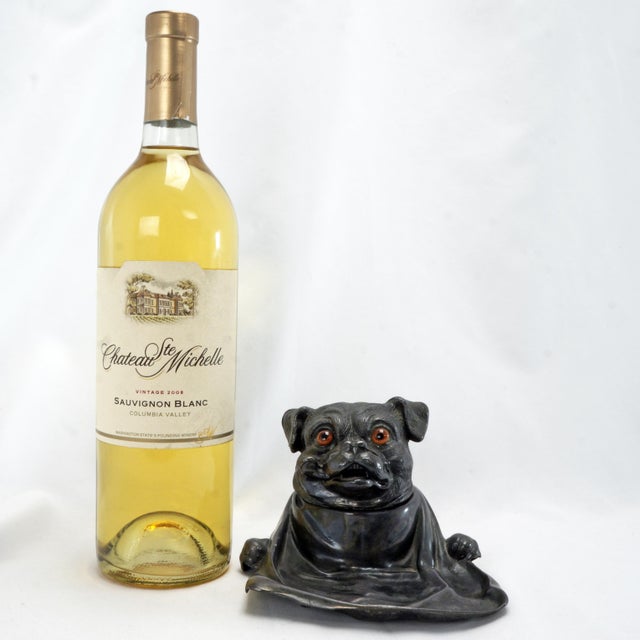 An adorable inkwell of a pug dog smoking a pipe and outfitted with a large napkin. I love the brown glass eyes. The cast...