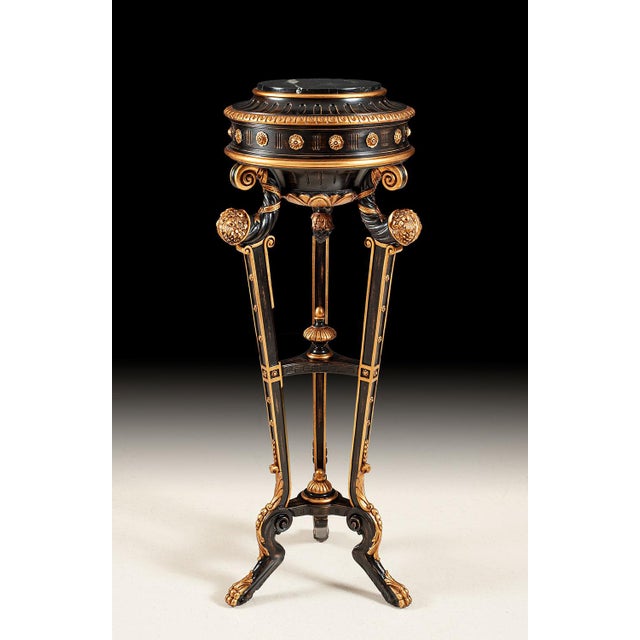 Crafted with precision in Italy, this plant stand features three intricately hand-carved posts and a striking rub-through...