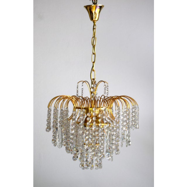 This luxurious waterfall chandelier features a gold-plated socket and is adorned with numerous Swarovski crystals. 3 E14...