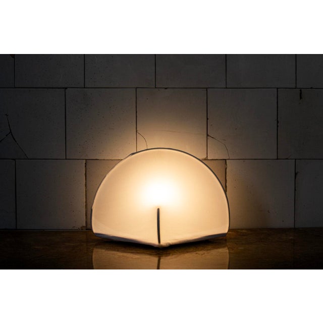 Table lamp with a metal frame and a stretch jersey shade. Model: Kaori 1 Design: Kazuhide Takahama Manufacturer: Sirrah...