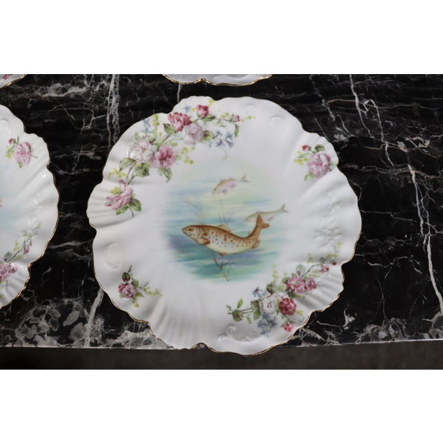 Limoges, made in France set of four plates with floral and fish pattern.