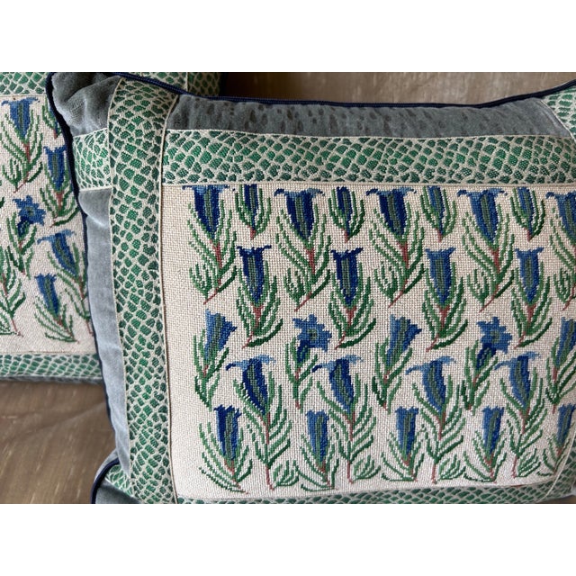 A pair of pillows made from hand stitched petit point, backed and trimmed with coordinating velvet