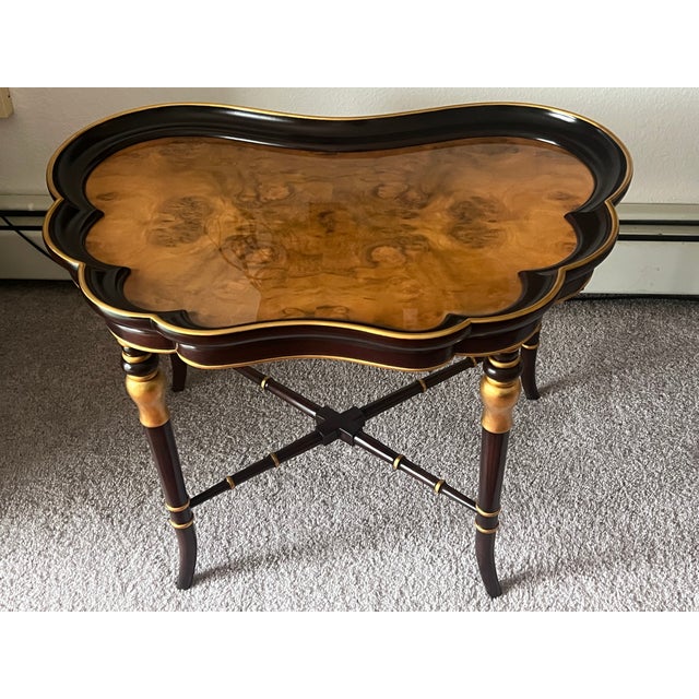 Small coffee/ side butterfly table with walnut burl top in high sheen and gold leaf accents. Rich ebany dark brown color.