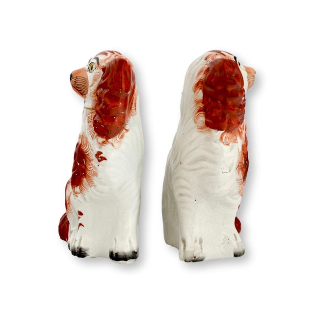 Mid 19th century Staffordshire pottery King Charles spaniel dogs modeled in the traditional seated form with expressive...