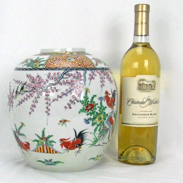 A large, colorful, hand painted Chinese polychrome ginger jar with a design of roosters in a garden. The hand thrown...