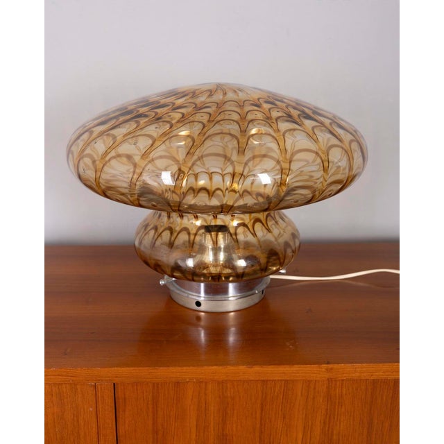 Table lamp with a chromed metal base and a large mushroom-shaped shade in hand-blown amber Murano glass. Italian design,...