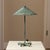 Sculptural vintage table lamp featuring a beautifully aged verdigris patina, broad conical shade with star-shaped...