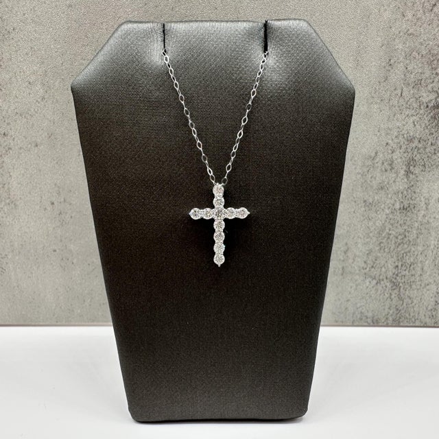 This natural diamond cross necklace is crafted in 14kt white gold and features a timeless cross pendant set with 0.64...