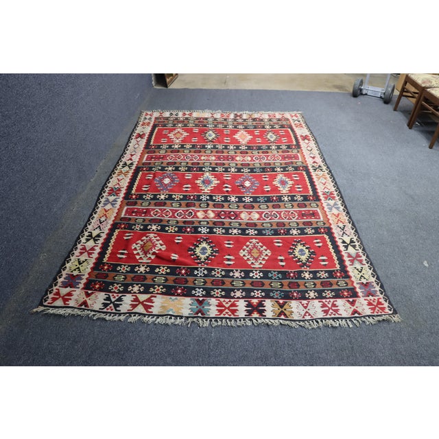 Southwestern style handwoven wool rug with bold red, navy, and ivory geometric patterns. Features diamond and tribal...