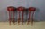 Bar stools with painted metal bases and copper leg bands; the seats are upholstered in burgundy vinyl. Very good...