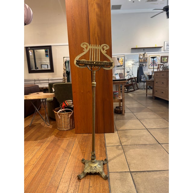 Vintage brass music stand with claw foot detail and lyre shaped music book holder. Adjustable height.