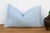A four-petal flower-star medallion, hand block-printed in white, repeats across a soft powder blue linen ground on this...