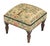 Meticulously handcrafted in the United Kingdom, this upholstered stool boasts classic studding and hand-polished solid...