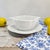 This Limoges porcelain gravy boat combines luminous white porcelain with a graceful scalloped silhouette and a permanently...