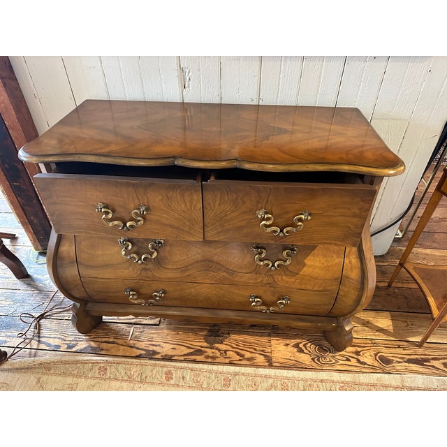 Beautiful bookmatched Bombay style serpentine dresser having gorgeous workmanship by Baker Furniture Co. Two medium sized...