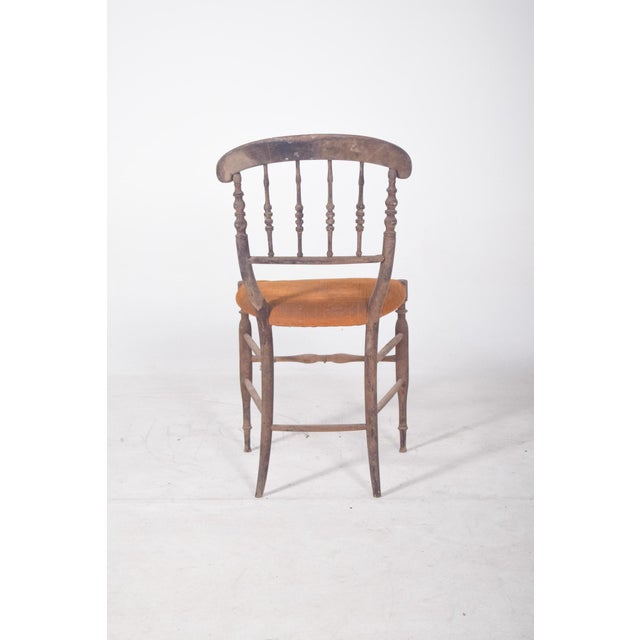 Dark wood dining chair. with a curved back and a backrest made of turned wood that evokes the elegance of 19th century...