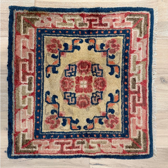 Hand-knotted wool rug measuring 2'0" x 2'2" (24" x 26"), featuring a central floral medallion with stylized botanical and...