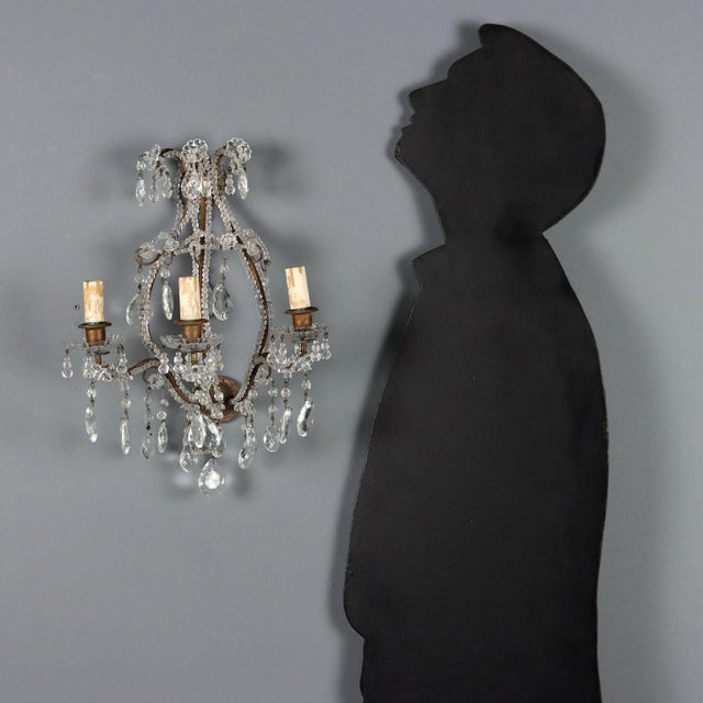 Set of four wall lamps in burnished metal and glass. Three lights supported by curved arms, embellished with clear glass...