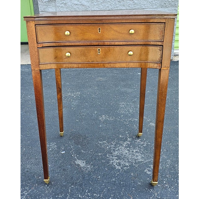 A Baker Furniture Company Hictoric Charleston Collection Two Drawer Side Table with tapered legs termination with brass...