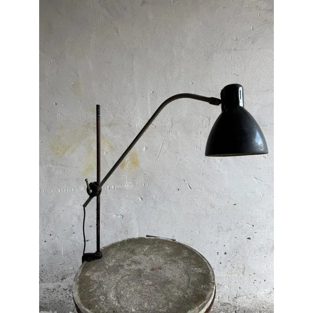 This rare vintage screw-on industrial lamp features a sleek black metal shade and an elegant curved arm attached to a...