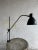 This rare vintage screw-on industrial lamp features a sleek black metal shade and an elegant curved arm attached to a...